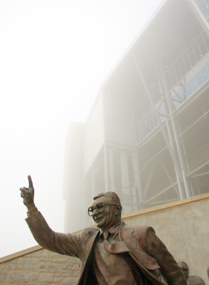Joe Paterno sculpture with fog and Beaver Stadium